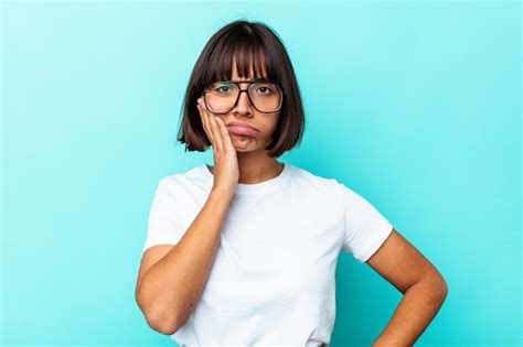 Mujer Joven De Raza Mixta Aislada Sobre Fondo Azul Sopla Las Mejillas