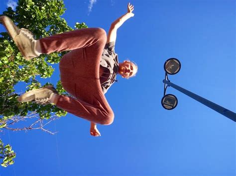 Premium Photo Low Angle View Of Man Jumping Against Clear Blue Sky On