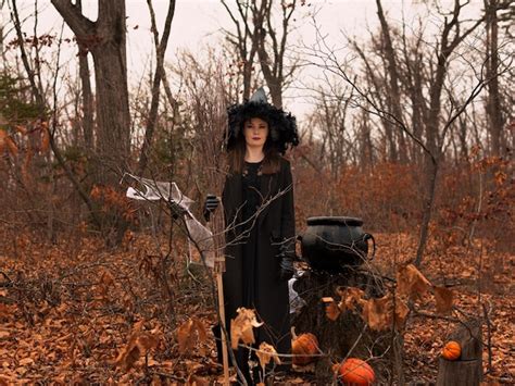 Premium Photo Beautiful Woman In Witches Hat And Costume Holding