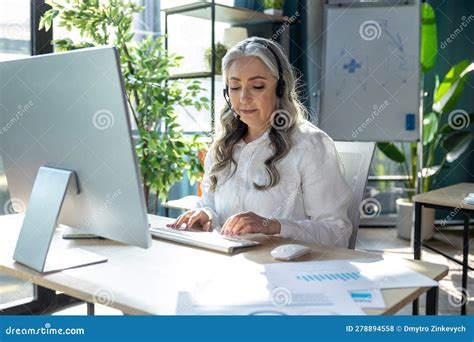 Good Looking Mature Business Woman At The Computrer Looking Busy Stock