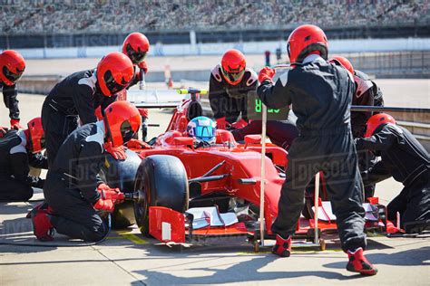 Pit crew working on formula one race car in pit lane - Stock Photo ...