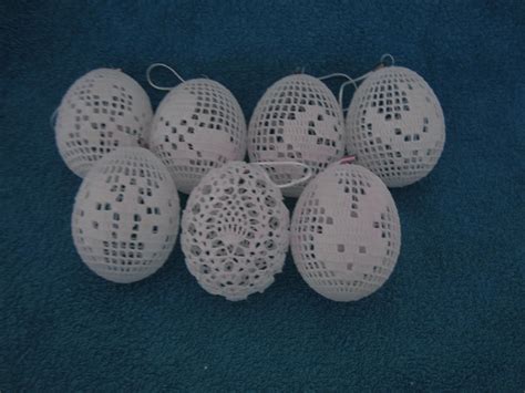 Six White Lace Balls With Holes On Them Sitting On A Blue Carpeted