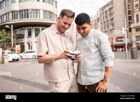 A Joyful Multiethnic Gay Couple Sharing A Moment On A City Street As