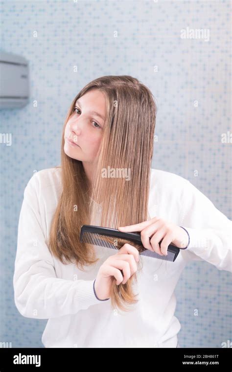 Une Belle Fille Blonde Combat Elle M Me Ses Cheveux Regardant Dans Le Miroir Dans La Salle De