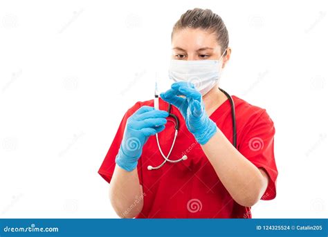 Young Medical Nurse Wearing Red Scrub Preparing Syringe Stock Photo