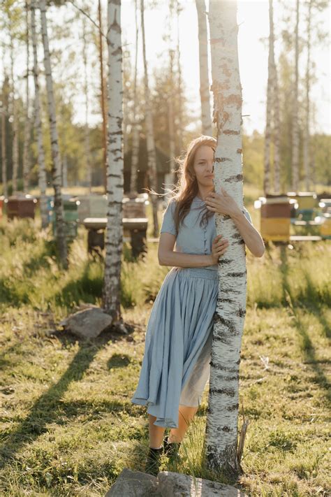 Woman In White Sleeveless Dress Standing On Green Grass Field · Free