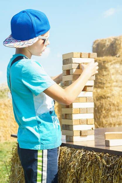 Vista Lateral De Un Ni O Preadolescente Jugando Al Juego De Mesa Jenga