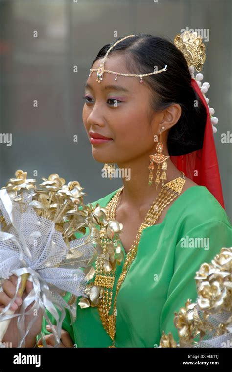 Malaysian Female Dancer In Traditional Costume And Gold Jewelry Holding