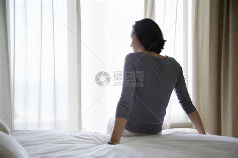 坐在床后视线上看窗边的女人高清图片下载 正版图片321986546 摄图网