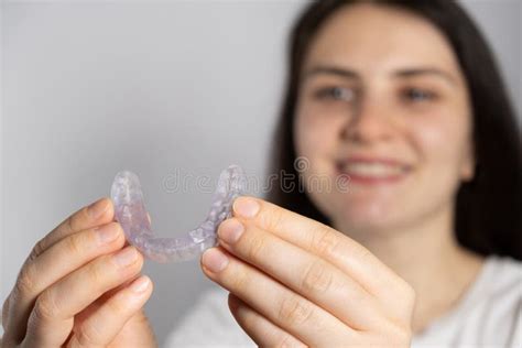 A Woman Holds Dental Mouthguard Splint For The Treatment Of