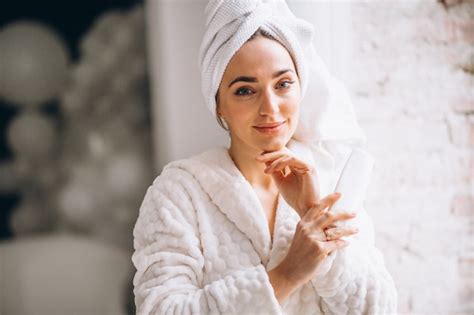 Femme En Peignoir Avec Une Lotion Pour Le Corps Photo Gratuite