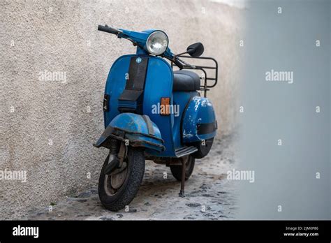 A Blue Vespa Motorcycle Parked Near A Wall Stock Photo Alamy