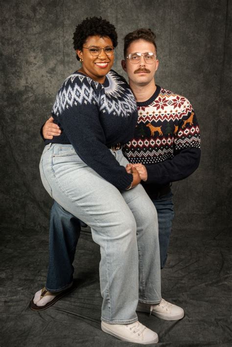 Two People Posing For A Photo In Front Of A Black Background One