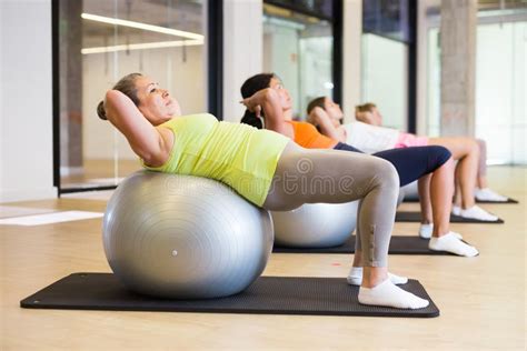 Mature Female Performing Set Of Exercises With Pilates Ball Stock Photo