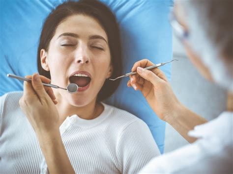 Premium Photo Smiling Brunette Woman Being Examined By Dentist At Dental Clinic Hands Of A
