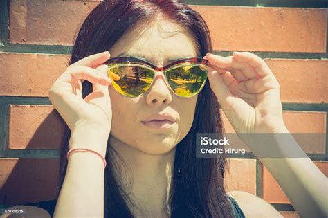 Beautiful Woman With Sunglasses Posing Next To The Brick Wall Stock