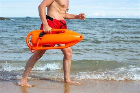 Seitenansicht Rettungsschwimmer läuft am Strand Kostenlose Foto