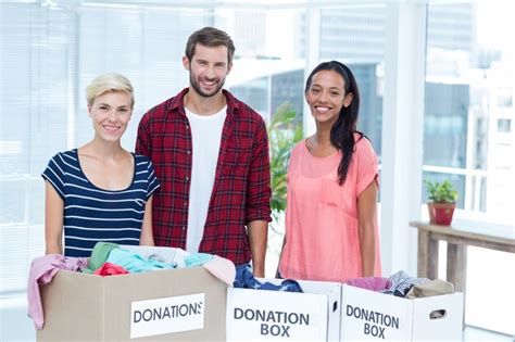 Premium Photo Smiling Young Friends Volunteers Separating Clothes