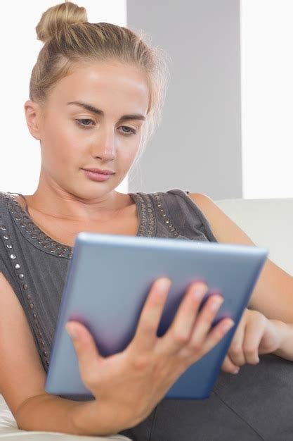 Premium Photo Casual Serious Blonde Relaxing On Couch Using Tablet