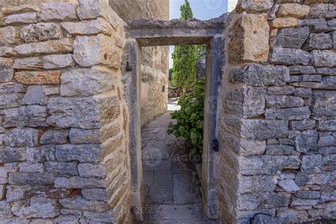 View through an old stone door frame without a door into a backyard of
