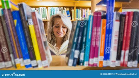 Smiling Female Student Reading Book In The Library Stock Photo Image