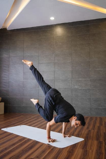 Free Photo | Yogi doing advanced hand stand yoga pose in gym