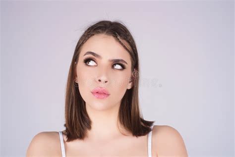 Portrait Of Thinking Woman With Confused Puzzled Face On Studio