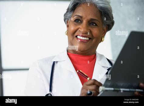 African Female Doctor Writing In Medical Chart Stock Photo Alamy