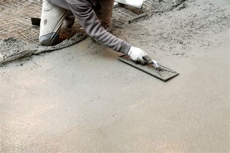 Travailleur Aplatissant Le Mortier De Ciment Sur Le Plancher Photo