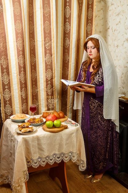 Premium Photo A Jewish Woman In A Veil Falling From Her Hair Prays At The Festive Table On