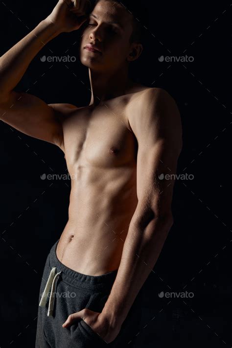 Half Naked Athlete In Gray Pants With A Pumped Up Torso On A Black Background Stock Photo By