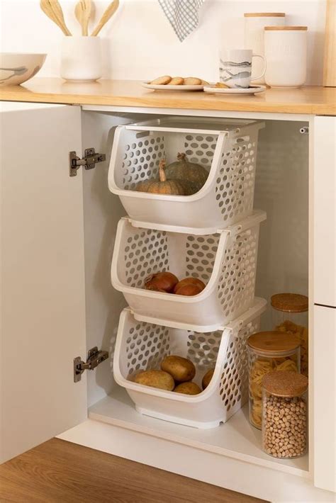 The Kitchen Cabinet Door Is Open And Has Three Baskets On It With Food