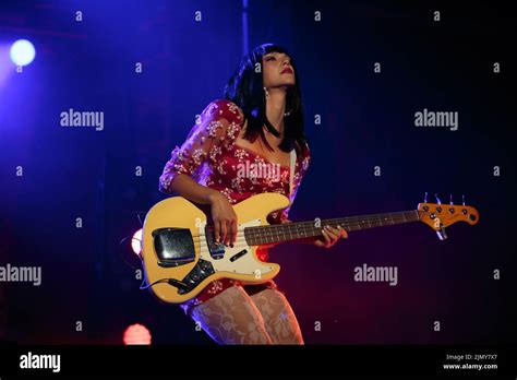 Bassist Laura Lee Of Khruangbin On Stage Wearing A Red Floral Mini Dress With White Stockings