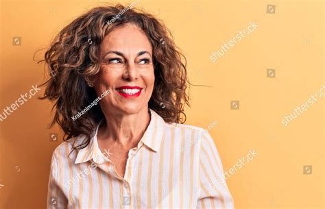 Middle Age Beautiful Brunette Woman Wearing Striped Shirt Standing Over