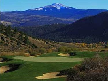 A Golf Course With Mountains In The Background