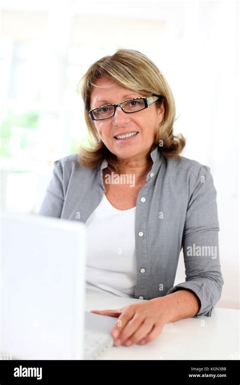 Senior Businesswoman Sitting In Front Of Laptop Computer Stock Photo