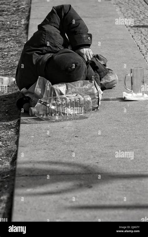 Un Disparo De Escala De Grises Vertical De Una Persona Indigente