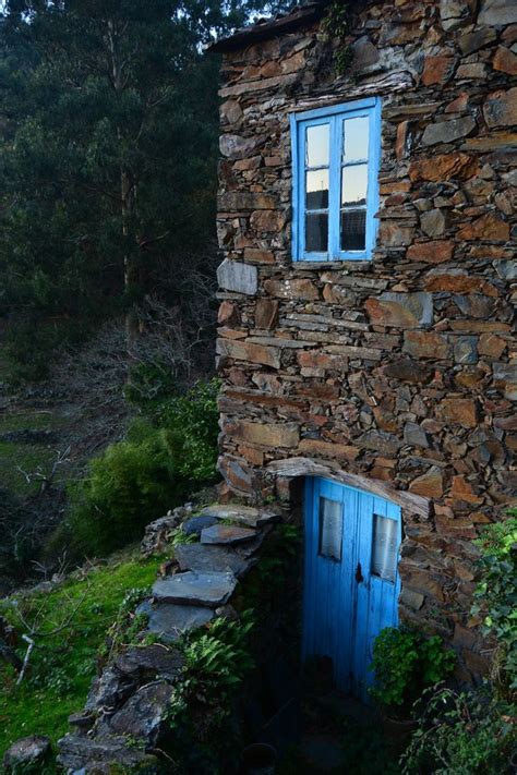 An Old Stone Building With A Blue Door And Window On The Outside