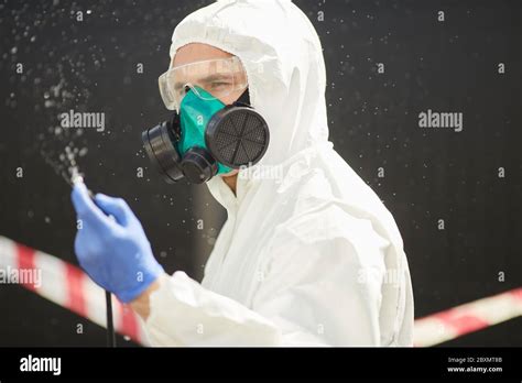 Chest Up Portrait Of Male Worker Wearing Hazmat Suit Holding