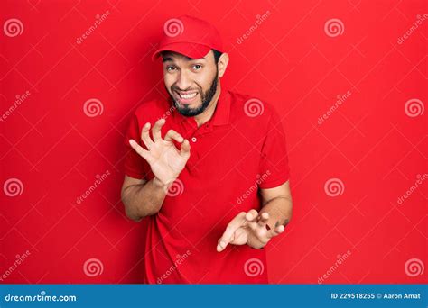 Hispanic Man With Beard Wearing Delivery Uniform And Cap Disgusted