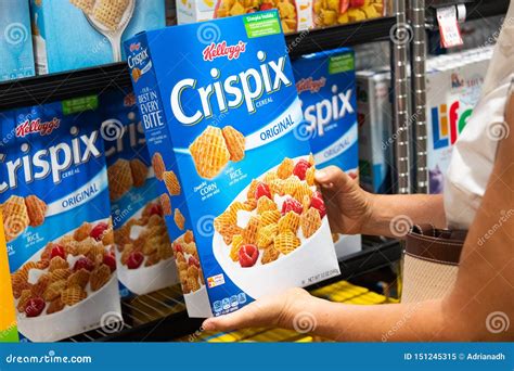 Shoppers Hand Holding A Package Of Kellogg`s Brand Crispix Cereal