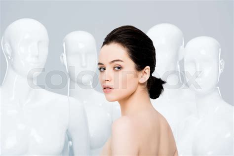 Beautiful Naked Girl Looking At Camera While Posing Near Mannequins