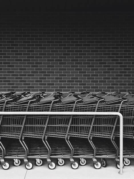 Premium Photo Shopping Carts Arranged In A Row By Wall