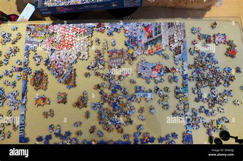 Partially completed jigsaw puzzle being completed Stock Photo - Alamy