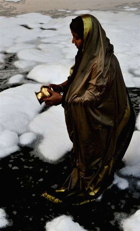 Devotees Offer Prayers While Taking A Holy Dip In The Yamuna River