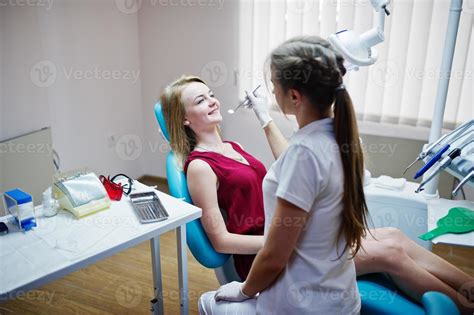 Attractive Patient In Red Violet Dress Laying On The Dental Chair While