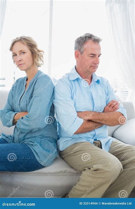 Middle Aged Couple Sitting On The Sofa Not Speaking After A Fight Stock