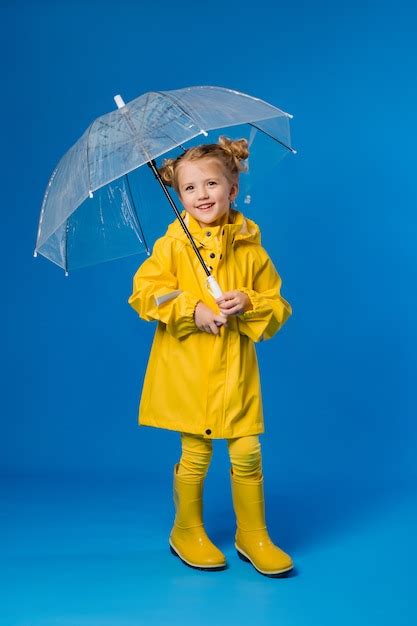 Menina Sorrindo Em Uma Capa De Chuva Amarela E Botas De Borracha