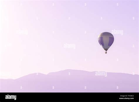 Hot Air Balloon In The Pink Sky Above Soft Sunrise Mountains Silhouettes With Copy Space Stock