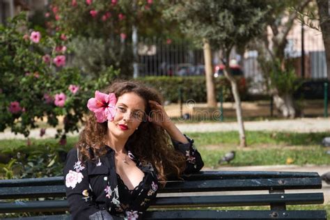 Belle Femme Blonde Aux Cheveux Bouclés Et Yeux Bleus Est Assise Sur Un Banc Du Parc Reposant La
